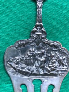 Tenedor en plata repujada con personajes en barco, mascarons y motivos vegetales estilizados.Holanda 1860.
    