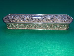 Estuche para bolígrafos plateado en relieve con motivos vegetales y rocalla Birmingham England 1912.
    