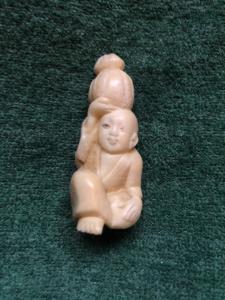 Ivory netsuke 'con figura sentada con calabaza en la cabeza, Japón.
    