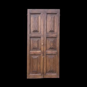 Coppia di porte in legno di castagno massello con formelle romboidali incise in altorilievo.