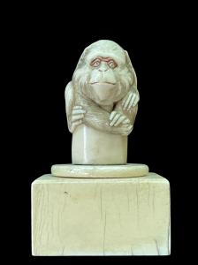 Pequeña escultura de marfil (pomo de bastón) sobre base cuadrada que representa a un mono. Japón.