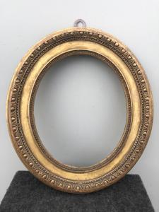Marco de madera tallada y pan de oro con motivos geométricos.