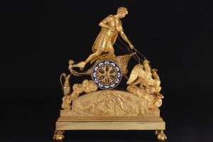Importante reloj de péndulo en bronce dorado y finamente cincelado que representa a Ganimedes en un carro, altura 53 cm, principios del siglo XIX