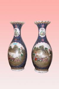 Pareja de jarrones chinos con forma de cráter en porcelana blanca decorada en azul con personajes en una escena rural.