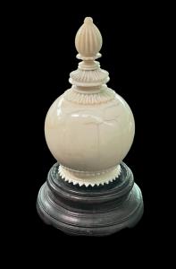 Porta perfume globular de marfil con motivos geométricos grabados.