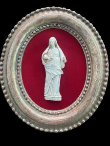 Bajorrelieve de marfil con figura de Santa. Marco ovalado de madera con hoja de oro.