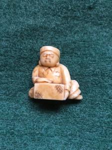 Netsuke’  con personaggio seduto con ceppo di legno.Giappone. 