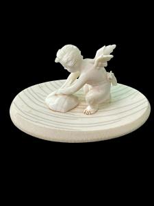 Pequeña escultura de marfil que representa a Cupido afilando su flecha.