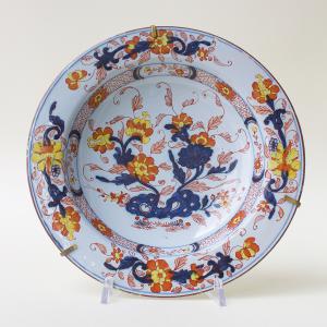 Serie di tre piatti in maiolica decorati a motivi floreali in policromia