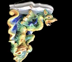 Mensola in maiolica con sostegno a forma di drago alato.Manifattura di Imola.