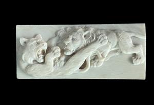 Placa-bajorrelieve de marfil que representa a dos leones luchando. Japón.