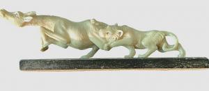 Escultura de marfil que representa un león cazando un antílope.
