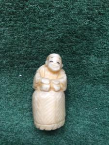 Netsuke’  con personaggio seduto su cesto di vimini.Giappone. 