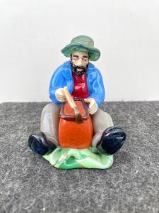 Scultura in vetro raffigurante personaggio seduto con cesto.Boemia.