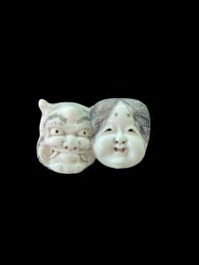 Netsuke de marfil representando dos máscaras de la comedia del arte japonesa.
